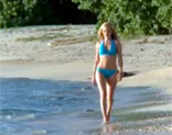 Modelo rubia posando desnuda en una solitaria y paradisiaca playa