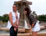 Rusa follada al aire libre junto a una fuente entre dos hombres